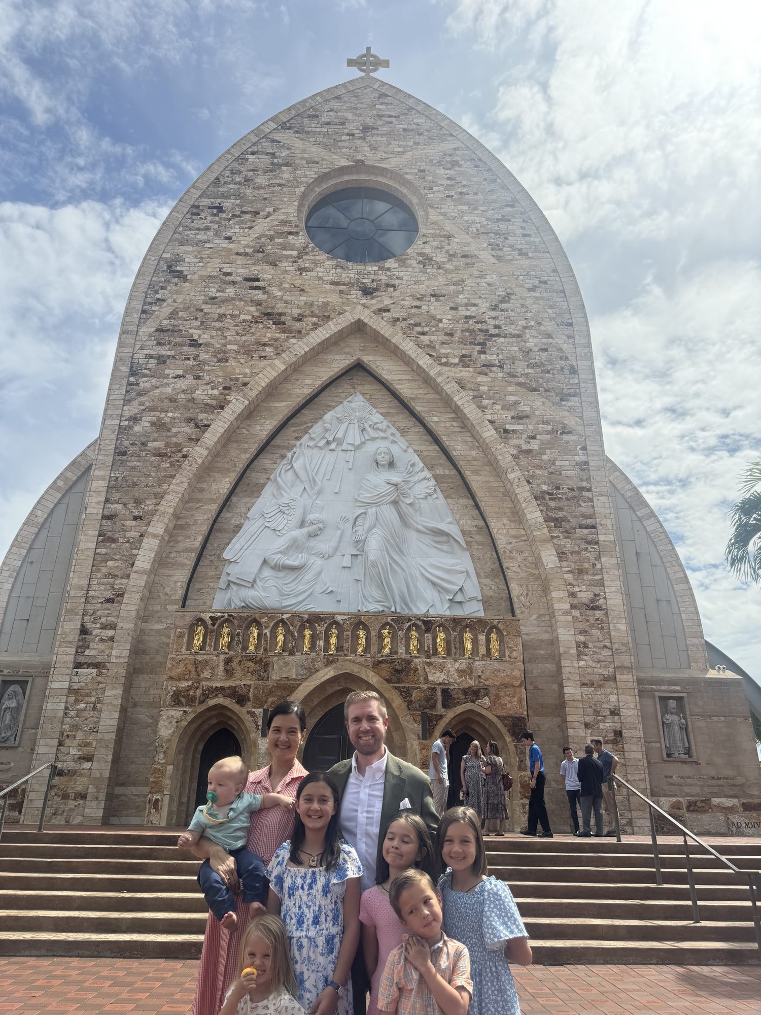 Greg Colker with his wife Jacqueline and their six children on the steps of the Ave Maria Catholic Church.
